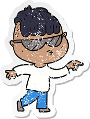 distressed sticker of a cartoon boy wearing sunglasses pointing