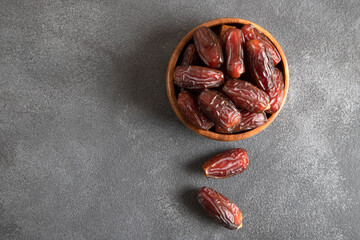 Date fruits in wooden bowl,on black background
