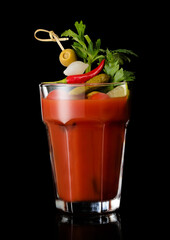 Vodka and tomato juice bloody mary cocktail in large glass on black background.