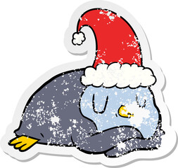 distressed sticker of a cartoon penguin wearing christmas hat