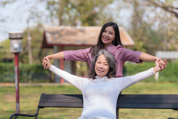 Asian mother and daughter sitting in the park happily and warmly.