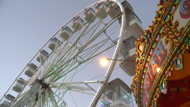 Carousel is spinning in front of the Ferris wheel