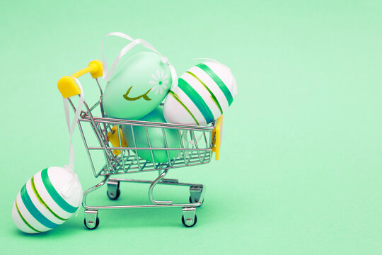 Easter eggs in the shopping cart on a green background