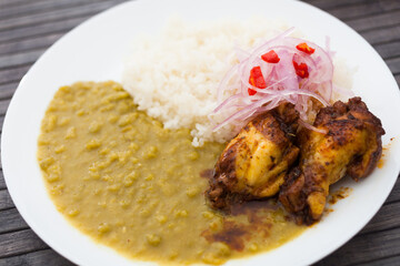 chicken wings with mashed peas, rice and pickled onions on white plate