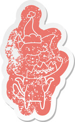 cartoon distressed sticker of a grinning fox wearing santa hat