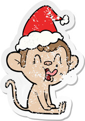 crazy distressed sticker cartoon of a monkey sitting wearing santa hat