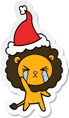 sticker cartoon of a crying lion wearing santa hat