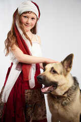 Portrait of Little girl in a stylized Tatar national costume with big shepherd dog on a white background in the studio. Photo shoot of funny young teenager who is not professional model