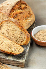 Fresh bread with seeds, sesame cut into pieces on a cutting board. vertical image. top view. place for text
