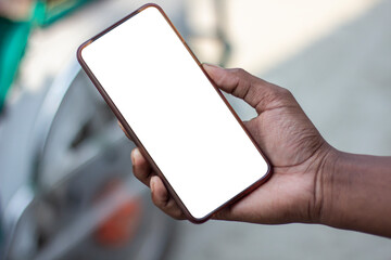 A man is holding a mobile phone in his hand and the mobile screen mockup is a white color
