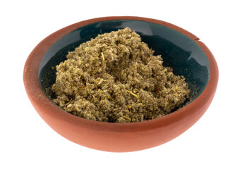 Side view of a small portion of crushed sage leaf in a bowl isolated on a white background.