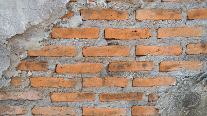 Close up of a weathered brick and stucco plaster wall. Background of brick wall texture.