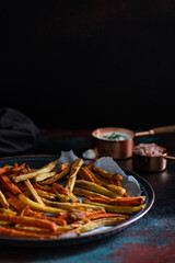 Healthy homemade oven baked sweet potato and carrot fries served with yogurt and green onion sauce. Low calorie vegetarian snack