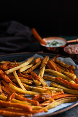 Healthy homemade oven baked sweet potato and carrot fries served with yogurt and green onion sauce. Low calorie vegetarian snack