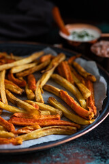 Healthy homemade oven baked sweet potato and carrot fries served with yogurt and green onion sauce. Low calorie vegetarian snack
