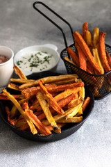 Healthy homemade oven baked sweet potato and carrot fries served with yogurt and green onion sauce. Low calorie vegetarian snack