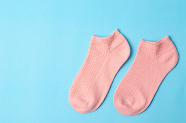 The pink color short socks on light blue background with copy space.