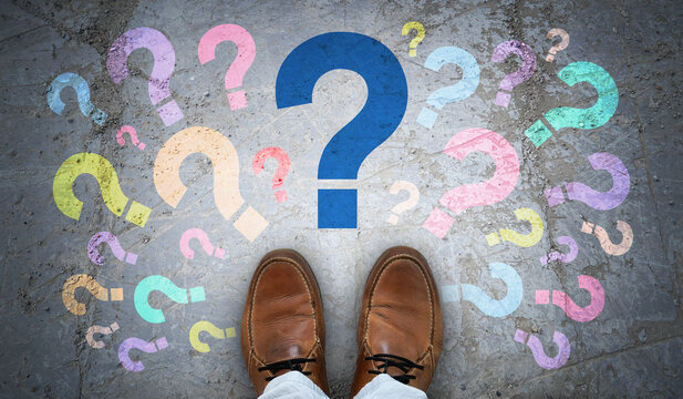 Brown leather shoes and many colorful question marks - doubt concept