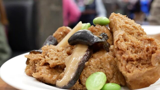 The motion of a dish of braised wheat gluten on a table inside a Chinese restaurant with 4k resolution.