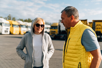 Mature woman and man at cargo warehouse, truck drivers delivery partners.