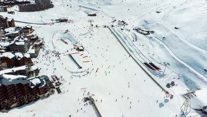 Aerial view of the snowy Val Thorens ski resort in the French Alps in winter - Luxurious hotels secluded in a white valley in altitude among high peaks and ski slopes