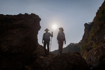 Tourists with backpacks hike on rocky top mountain trekking is adventure sport for Traveller who love hiker on summer holidays trekking and activity.