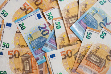 Euro money banknotes. Bundle of 50 and 20 euro bills on white wooden background. Flat lay of euros banknotes