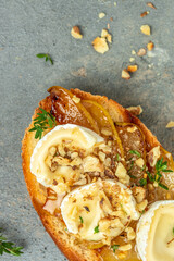 toasts croutons with cheese camembert and pear, honey, walnut, vertical image. top view. place for text