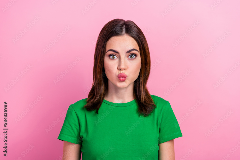 Wall mural photo of sweet shiny lady dressed green t-shirt sending you kiss lips pouted isolated pink color bac