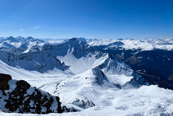 Alpine valley, snowy mountains in Switzerland. Panoramic view over the mountains during winter. Ski area Arosa, Lenzerheide in Switzerland. Winter sports in the snowy mountains.