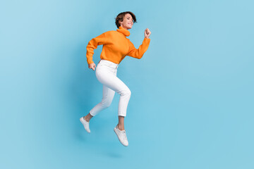 Fototapeta na wymiar Full length photo of lovely young lady running fast rush speed shopping dressed stylish orange clothes isolated on blue color background
