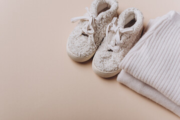 Baby boy knitted clothes, sweater, pants, shoes on beige background. Knitwear. Merino wool, cashmere concept
