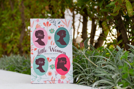 Close up Louisa May Alcott's Little Women Novel in The Garden. 