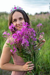 Pretty Woman Holding Bouquet of Fireweed Flowers. High quality photo
