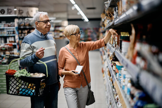 Senior couple buying groceries in supermarket. - Powered by Adobe