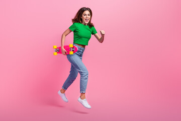 Full length photo of impressed lady dressed t-shirt jumping running fast holding skate empty space isolated pink color background