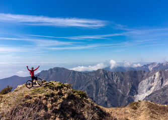 Un mountain biker su di una vetta delle Alpi Apuane in un giorno di primavera in Alta Versilia, Toscana.