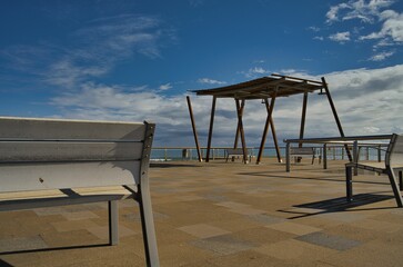 Beautiful view of benches on a shore with a sea in the background