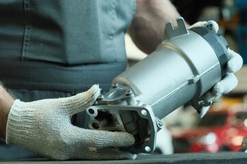 Maintenance and repair in a car service. A fuel filter for a diesel engine in the hands of an auto...