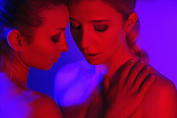  Portrait of two girls as a couple in cool red neon light.