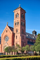 Fototapeta premium The facade of the historic neo-gothic catholic church with a bell tower in the city of Poznan