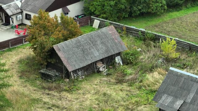 Aerial footage of old barns and a new house with a car parked in the yard