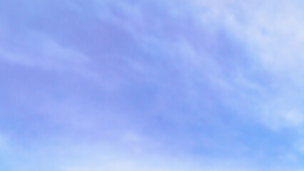 Texture of a blue sky in winter but still clear slightly veiled by a light haze and light clouds