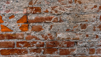 Brick wall texture with concrete residues still on the outermost part now aged by the weather and...