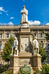 Monument of Leonardo Da Vinci on Piazza Della Scala in Milan, Italy. Built in 1872, sculptor Pietro Magni. The Master and his favorite apprentices. - obrazy, fototapety, plakaty