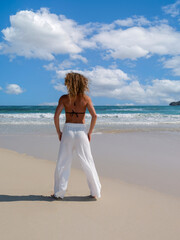 Fototapeta na wymiar woman is standing on the beach and enjoying the sea view