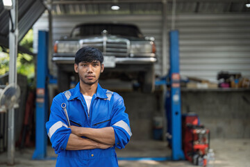 Portrait Shot of a Handsome Mechanic Working on a Vehicle in a Car Service. Professional Repairman...