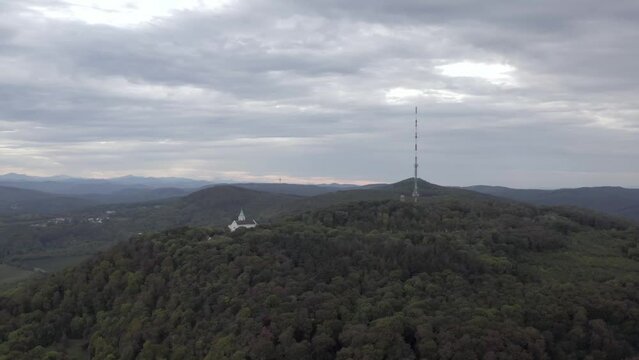 Beautiful view of a building and tower with radio antennas on a hill