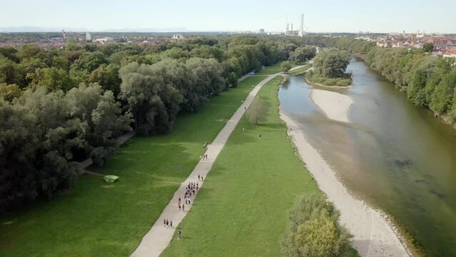 Beautiful view of people walking in a park with a river in the city of Munich, Germany