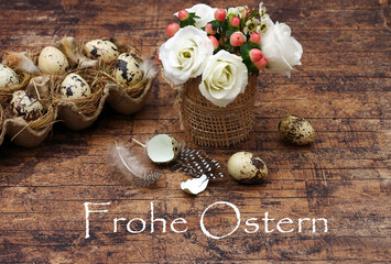 Harmonische Osterdekoration mit Blumenstrauß, Wachteleiern und dem Text Frohe Ostern auf altem Holz.